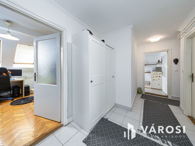 Látszó fagerendás tetőtéri lakás csendes utcában